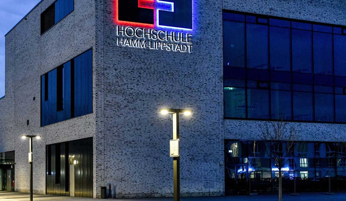 Hochschule Hamm-Lippstadt abends mit Logo und Beleuchtung.